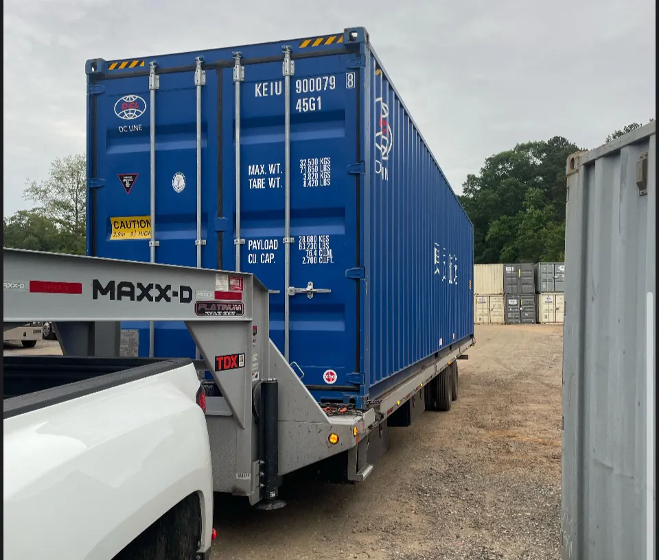 Used Wind and Water Tight shipping container on a delivery trailer (40ft High Cube shown)